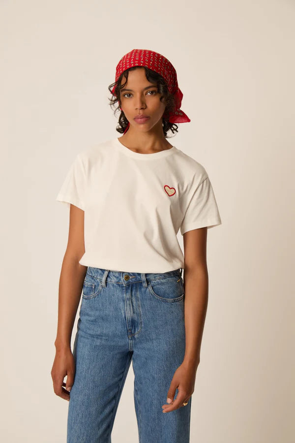 Modèle portant le t-shirt écru Ilian DES PETITS HAUTS avec écusson cœur brodé et jean bleu