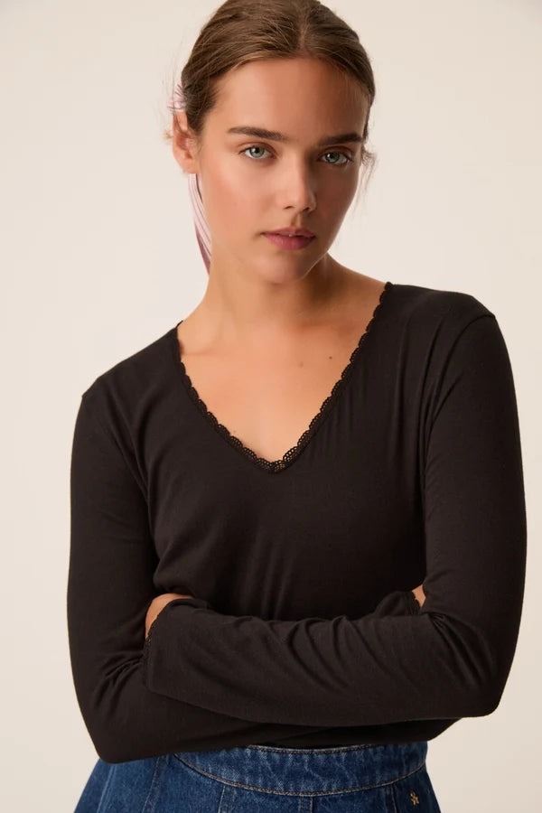 Zoom sur le décolleté en V bordé de dentelle du t-shirt noir Izolène DES PETITS HAUTS
