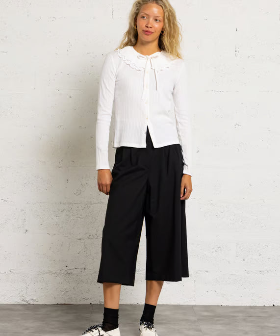 Silhouette complète modèle avec le top écru Zea DES PETITS HAUTS, pantalon large noir et derbies