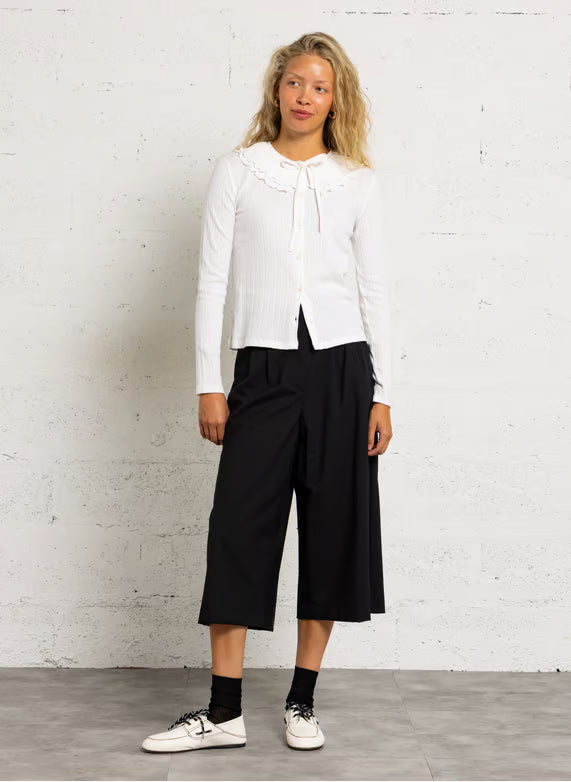 Silhouette complète modèle avec le top écru Zea DES PETITS HAUTS, pantalon large noir et derbies