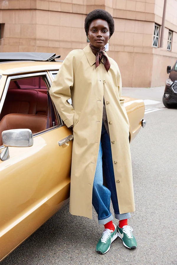Modèle portant le trench long beige Yvette DES PETITS HAUTS avec un jean et un foulard