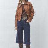 Silhouette complète avec la veste courte tabac Dune SUNCOO FEMME, jupe-culotte en jean et bottes en daim