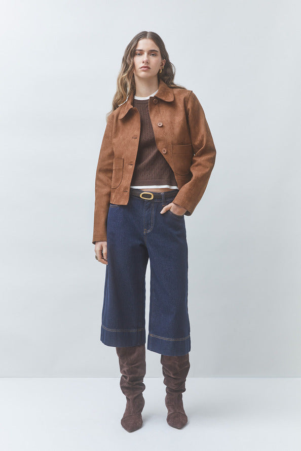 Silhouette complète avec la veste courte tabac Dune SUNCOO FEMME, jupe-culotte en jean et bottes en daim