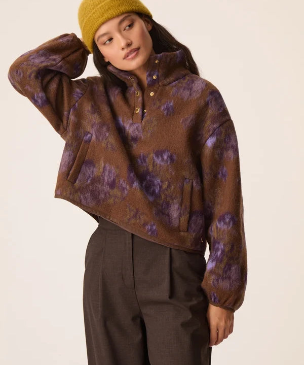 Modèle portant la veste courte en laine bouclette Isidore Violet Garden DES PETITS HAUTS avec un bonnet moutarde