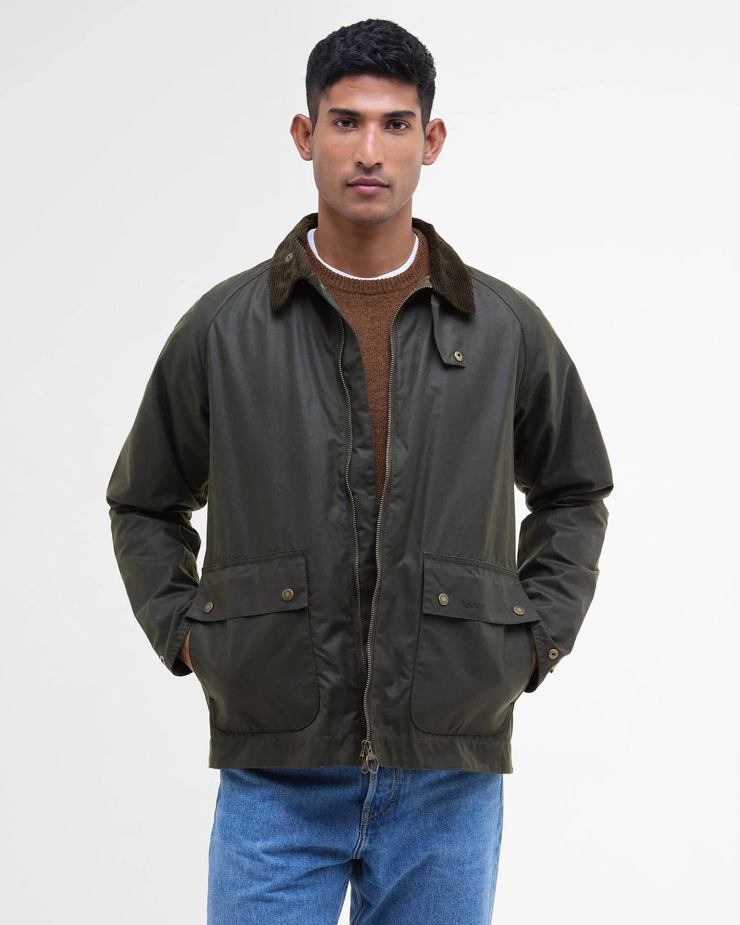 Mannequin portant la veste ciree courte Bedale vert fougere BARBOUR HOMME fermee sur un pull brun