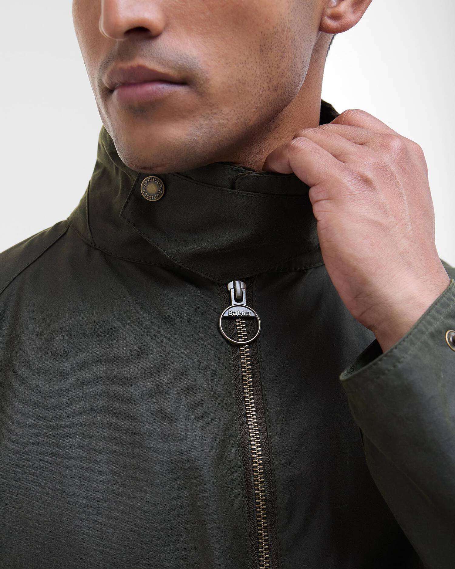 Gros plan sur le col en velours cotele et le zip metallique de la veste ciree Bedale Barbou