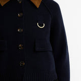 Gros plan sur la maille marine, les boutons effet corne, l'anneau en D doré et le col en velours de la veste Alverstone Barbour