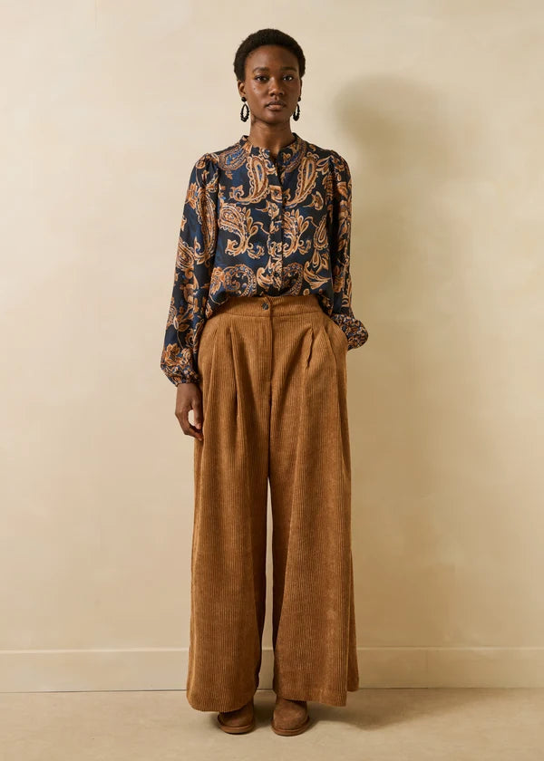 Vue en pied du mannequin portant la blouse fluide Getanoa bleu encre et pantalon large marron