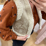Gilet sans manches Lola Espeleta écru – détail broderies florales et bordures bouclées
