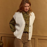 Gilet sans manches Type Lola Espeleta écru – porté sur chemise imprimée avec pantalon camel