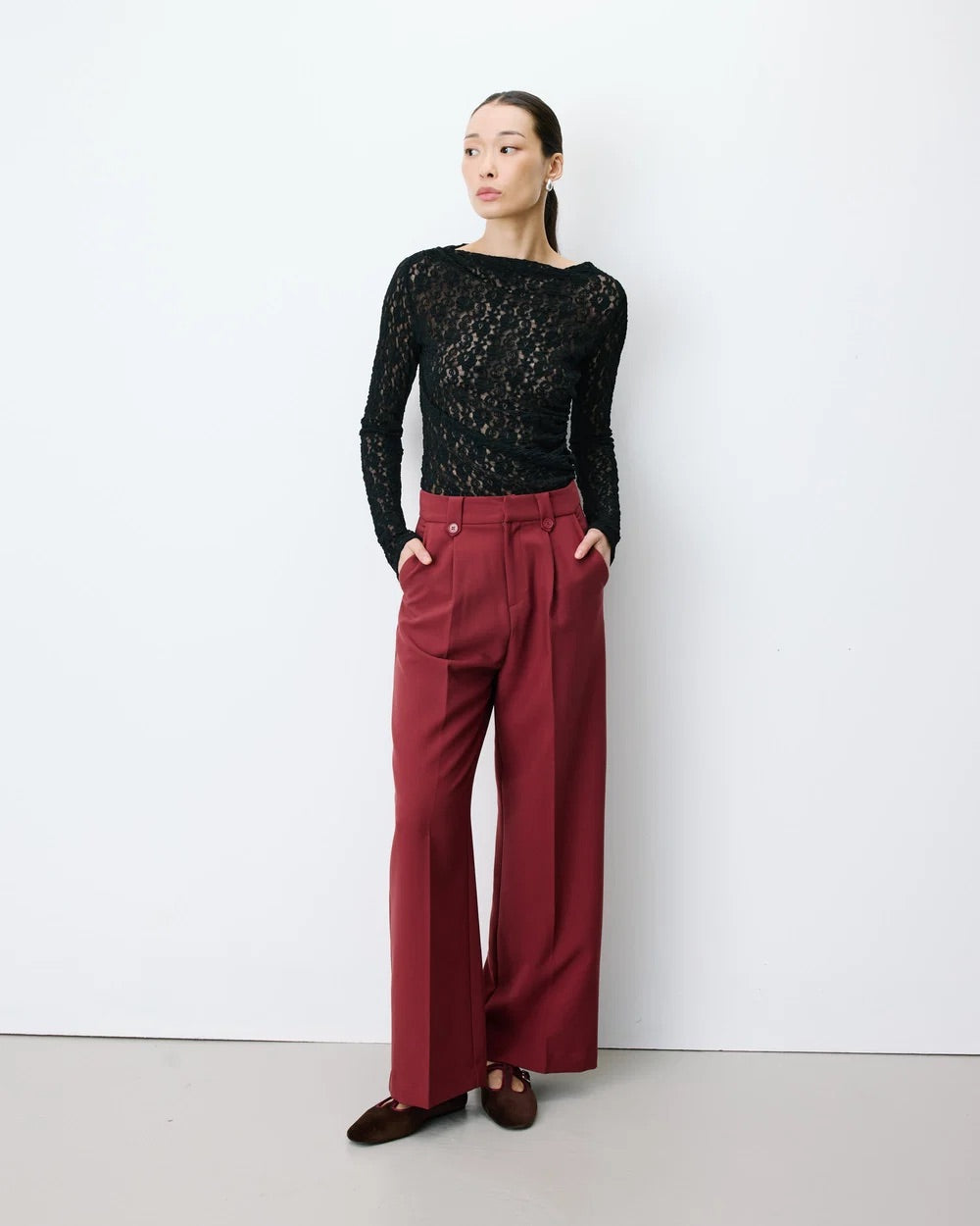 Pantalon large NILAY GRACE & MILA terracotta – porté de face avec haut en dentelle noire