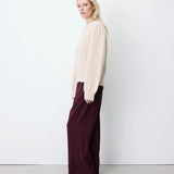 Pull ANTOINE GRACE & MILA beige – porté de profil avec pantalon large bordeaux